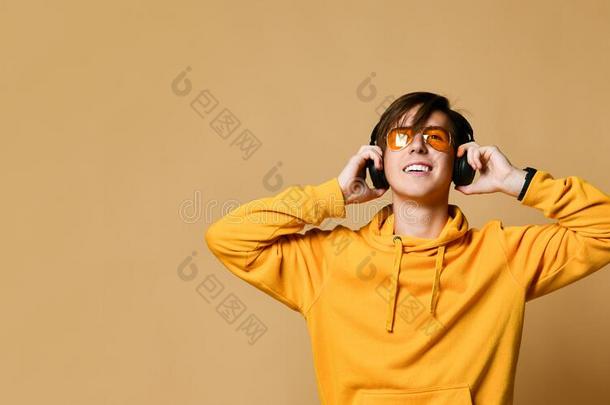 年幼的积极的青少年男孩采用黄色的连帽衫,太阳镜和头影