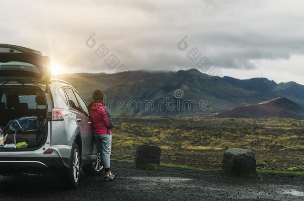 女人旅行者旅行在旁边多功能运动车汽车采用冰岛