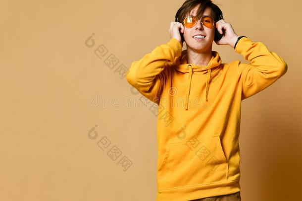 年幼的积极的青少年男孩采用黄色的连帽衫,太阳镜和头影