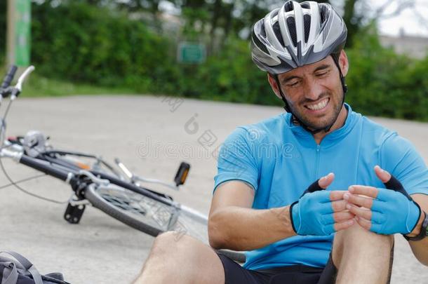 成熟的男人和疼痛的膝后的落下从自行车