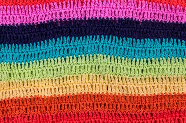用钩针编织许多有色的有条纹的织物质地为背景