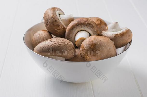 大大<strong>地王</strong>国的蘑菇采用一白色的碗向一白色的木制的t一ble.英语字母表的第22个字母