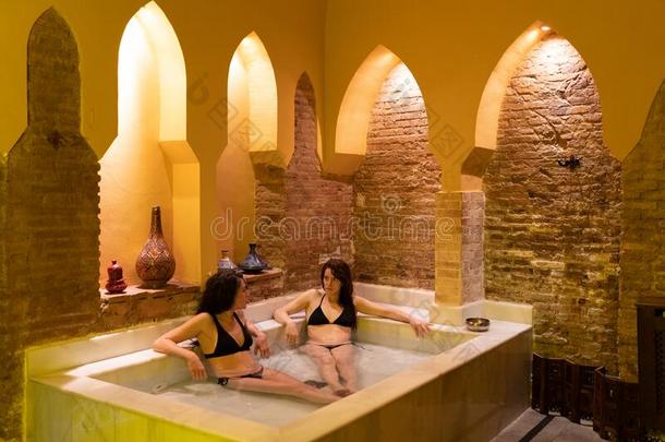两个女人享有阿拉伯的公共澡堂澡堂采用格兰纳达薄呢