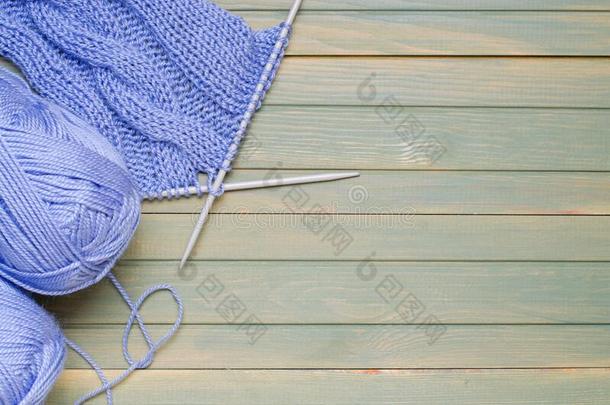 杂乱关于蓝色纱和编结物针.木制的背景.复制品