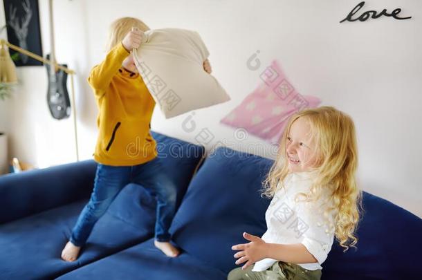 枕头战斗.淘气的学龄前儿童孩子们用于跳跃的向一sof一