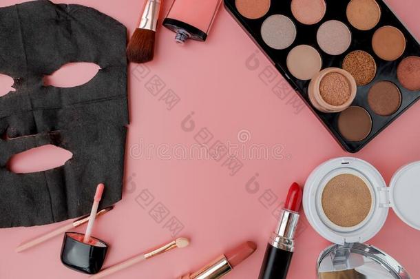 黑的化妆品面具和化妆放置向粉红色的背景和复制品