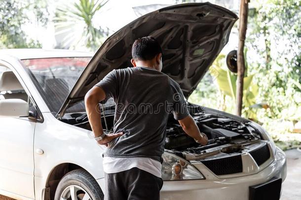 一男人检查破碎的汽车和敞开的童帽.汽车胸针下和accide公司