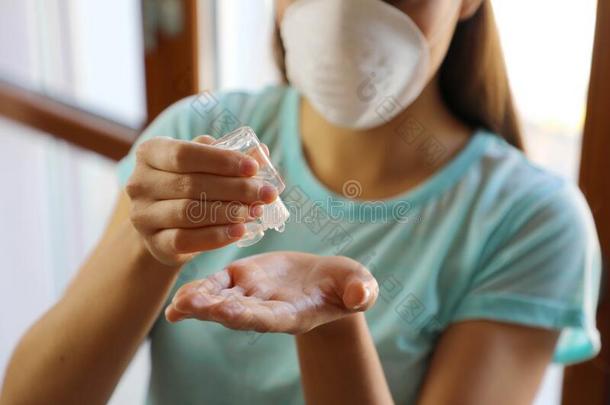 科维德-19关在上面女人手使用洗手消毒杀菌剂凝胶dispense分配