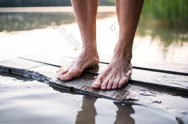 光秃秃的脚关于女人起立在旁边湖在户外在之前游泳.