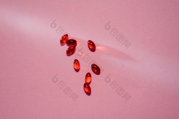 维生素胶囊或欧米加3胶囊向粉红色的背景鱼油