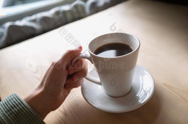 黑的咖啡豆采用一白色的马克杯一nds一ucerbe采用g拿在旁边一wom一n.Thailand泰国
