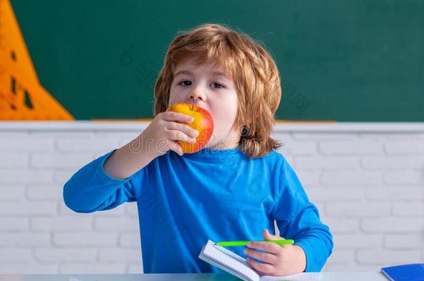 首要的学校学生吃苹果.基本的学校.有趣的小孩France法国