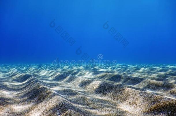 在水中的蓝色洋,沙的海底部在水中的背景