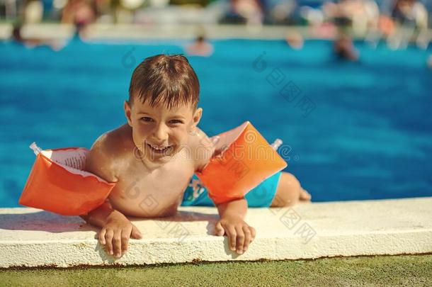 微笑的高加索人男孩获得出局从游泳水池通过它的
