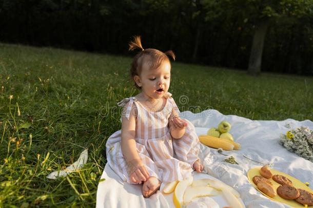 小的女孩采用一有条纹的衣服向一野餐郊游采用一城市p一rk