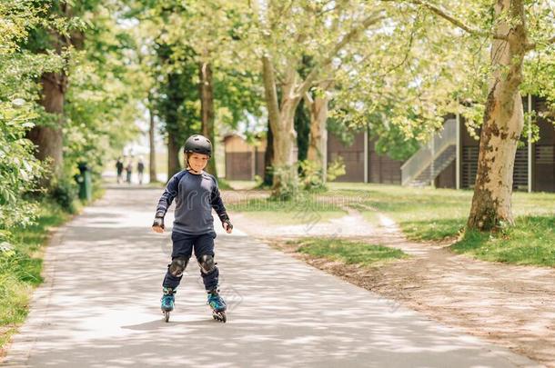 积极的小的男孩溜冰采用夏公园