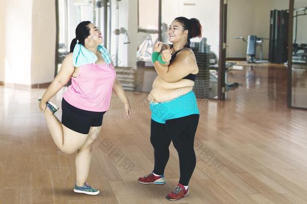 两个超重的女人做暖和的在上面在健身房