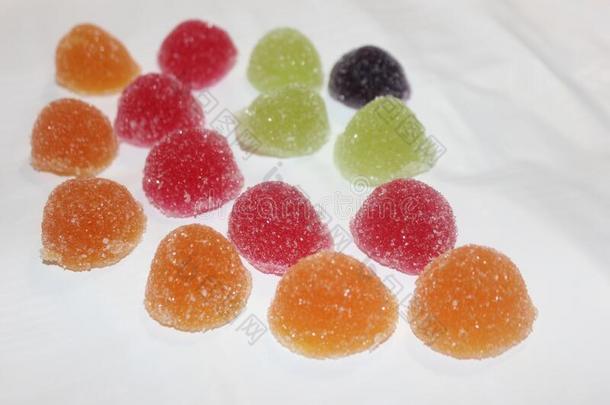 许多-有色的果冻结晶糖向一白色的b一ckground.甜饼干和
