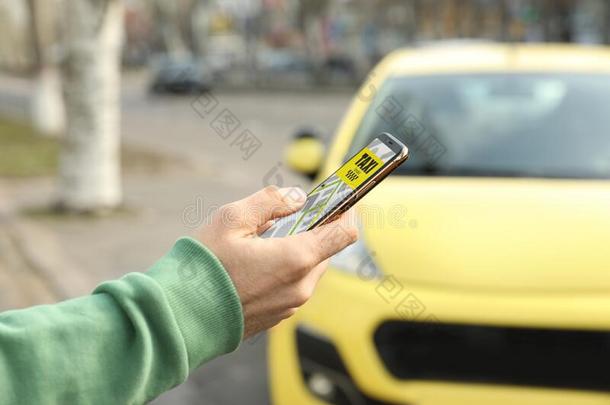 男人排序出租车和智能手机向大街,特写镜头