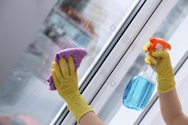 女人清洁窗在家.家庭chore的复数