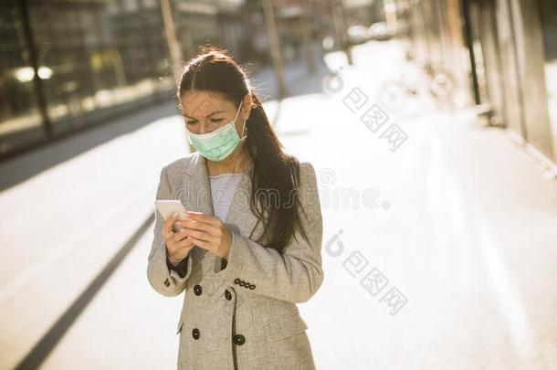 漂亮的年幼的女人和保护的面部的面具向指已提到的人大街