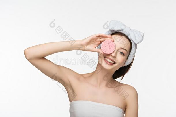 女孩掩蔽物眼睛和化妆品海绵
