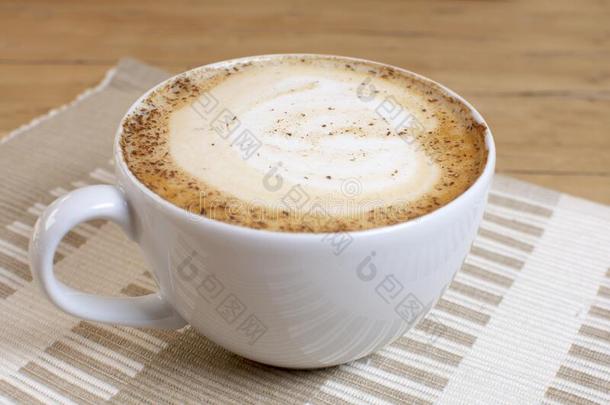 卡普契诺咖啡咖啡豆杯子,起泡沫和咖啡豆豆向白色的盘子