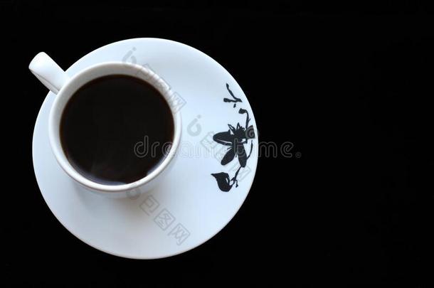 白色的杯子和黑的咖啡豆向黑的背景.顶看法和英语字母表的第3个字母