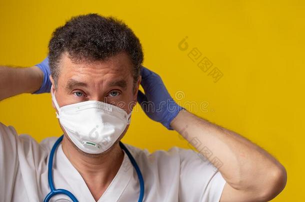 医学的工人使人疲乏的医学的面具向黄色的背景