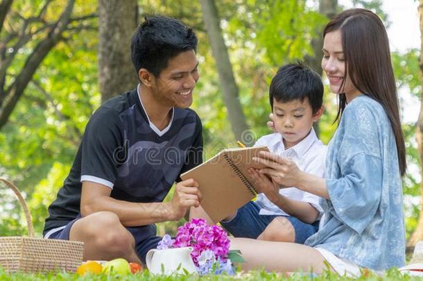 母亲和父亲是教学小孩采用公园和书.幸福的familiar熟悉的