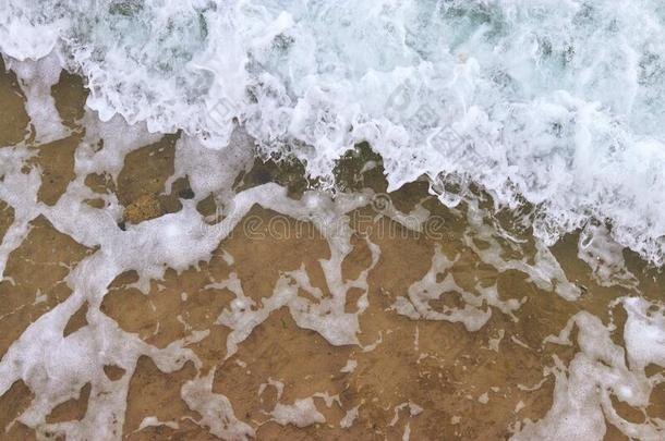 海滩质地.金色的沙和海起泡沫模式.海滩后座