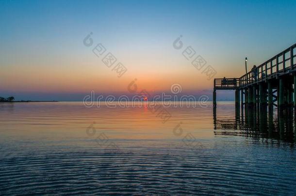 日落越过可移动的湾向指已提到的人亚拉巴马海湾海岸海景画在将饵食<strong>轻放</strong>水面