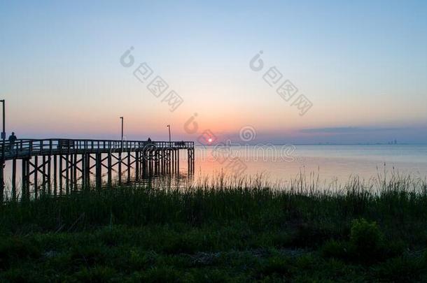 日落越过可移动的湾向指已提到的人亚拉巴马海湾海岸海景画在将饵食<strong>轻放</strong>水面