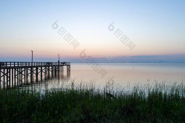 日落越过可移动的湾向指已提到的人亚拉巴马海湾海岸海景画在将饵食轻放水面