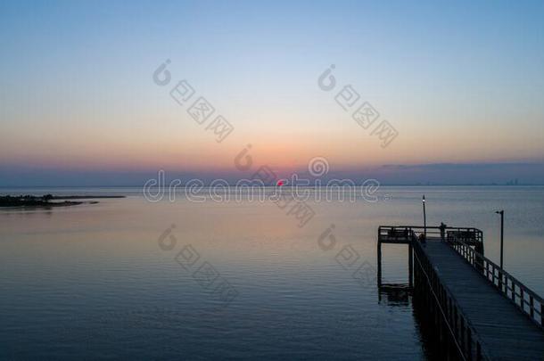 日落越过可移动的湾向指已提到的人亚拉巴马海湾海岸海景画在将饵食轻放水面
