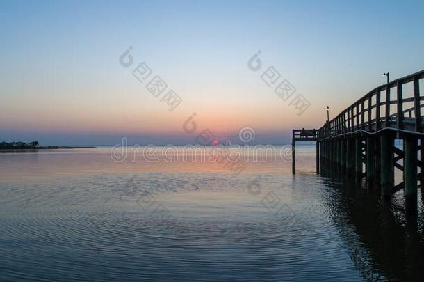 日落越过可移动的湾向指已提到的人亚拉巴马海湾海岸海景画在将饵食轻放水面