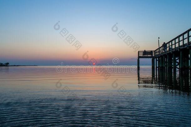 日落越过可移动的湾向指已提到的人亚拉巴马海湾海岸海景画在将饵食<strong>轻放</strong>水面