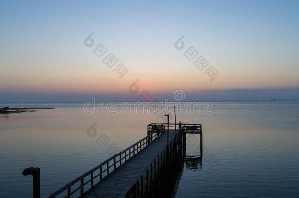 日落越过可移动的湾向指已提到的人亚拉巴马海湾海岸海景画在将饵食轻放水面