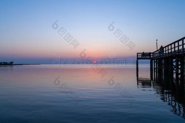 日落越过可移动的湾向指已提到的人亚拉巴马海湾海岸海景画在将饵食轻放水面