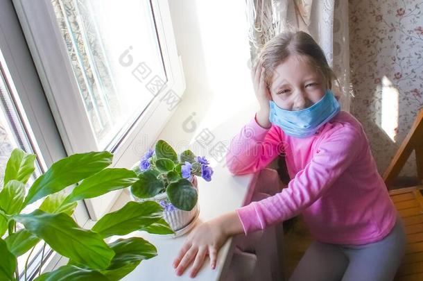日冕形病毒科维德-19.小的青少年女孩使人疲乏的面具为保护
