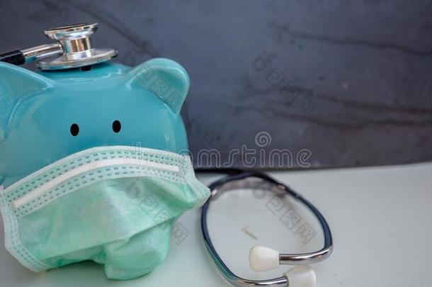 听诊器和小猪银行使人疲乏的保护的医学的面容面具,