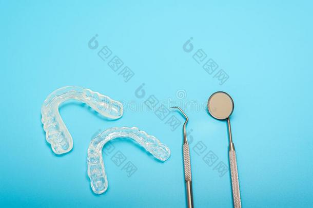 牙齿的转向轮安装角测定仪用过的在旁边牙齿的医生向蓝色背景