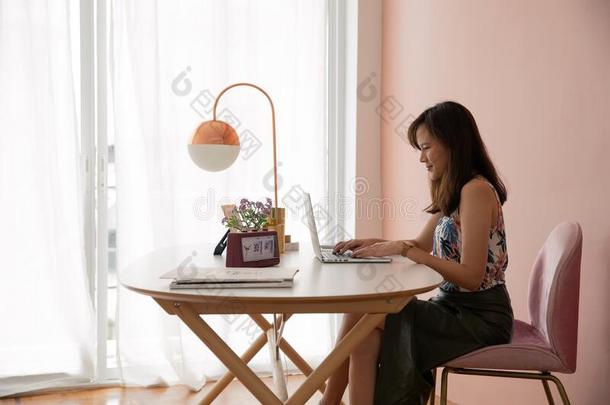 <strong>舒适</strong>的年幼的亚洲人女人<strong>自由</strong>作家坐向pinkchari和白色的design设计