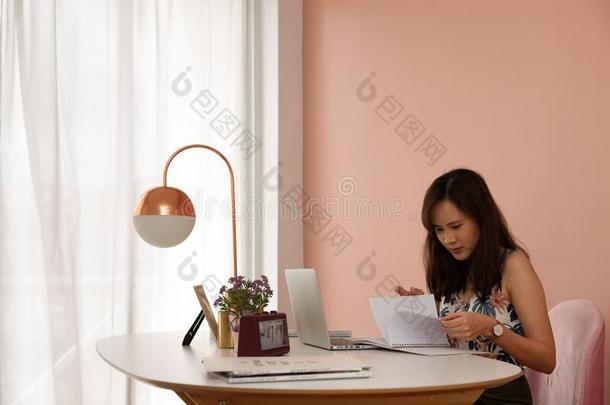 <strong>舒适</strong>的年幼的亚洲人女人<strong>自由</strong>作家坐向粉红和白色的design设计
