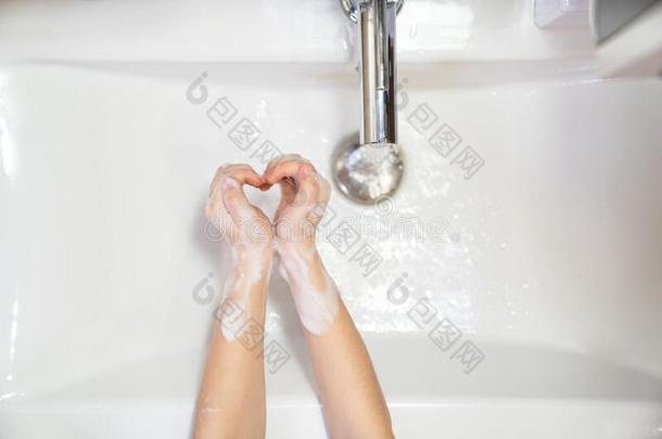 心洗涤孩子们手肥皂起泡沫和水
