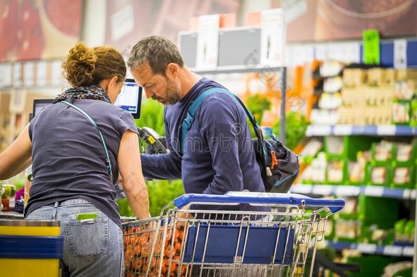 成熟的高加索人对购买食物和用品采用超级市场购物中心