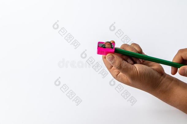 年幼的孩子们手使用粉红色的颜色铅笔卷笔刀为铅笔