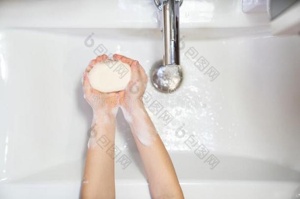 洗涤关于孩子们手肥皂起泡沫和水