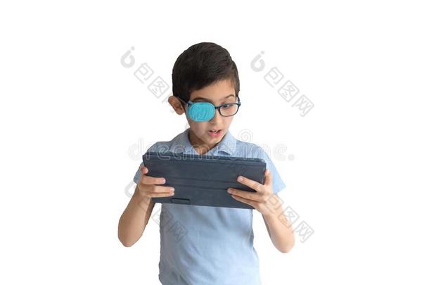 肖像关于男孩采用眼镜和补丁为眼镜.男孩和tablet药片