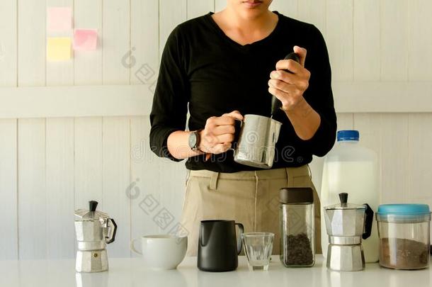 咖啡馆准备咖啡的员工是（be的三单形式冒热气的,奶<strong>发泡</strong>剂拿铁咖啡艺术采用咖啡豆马克杯在homonym同音异义词
